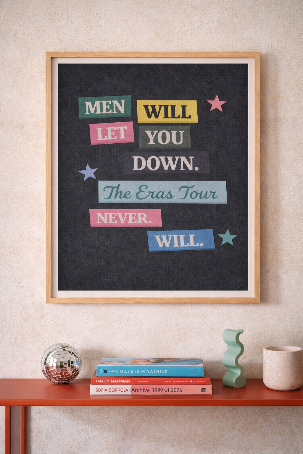 Framed art print reading “Men will let you down. The Eras Tour never will” displayed on a light plaster wall with modern decor